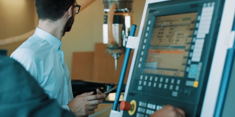 two engineers programming a CNC machine